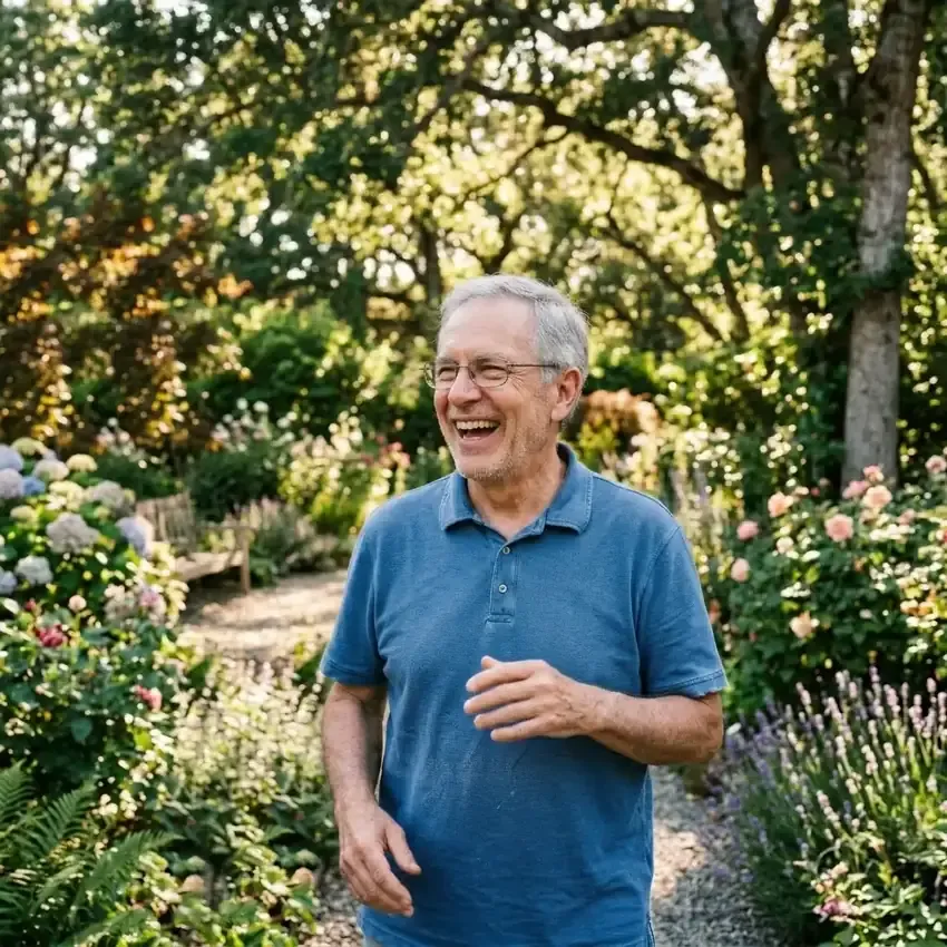 An older man laughing in a garden