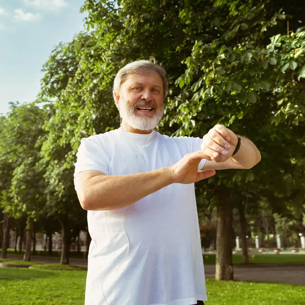 A man checking his watch in a park
